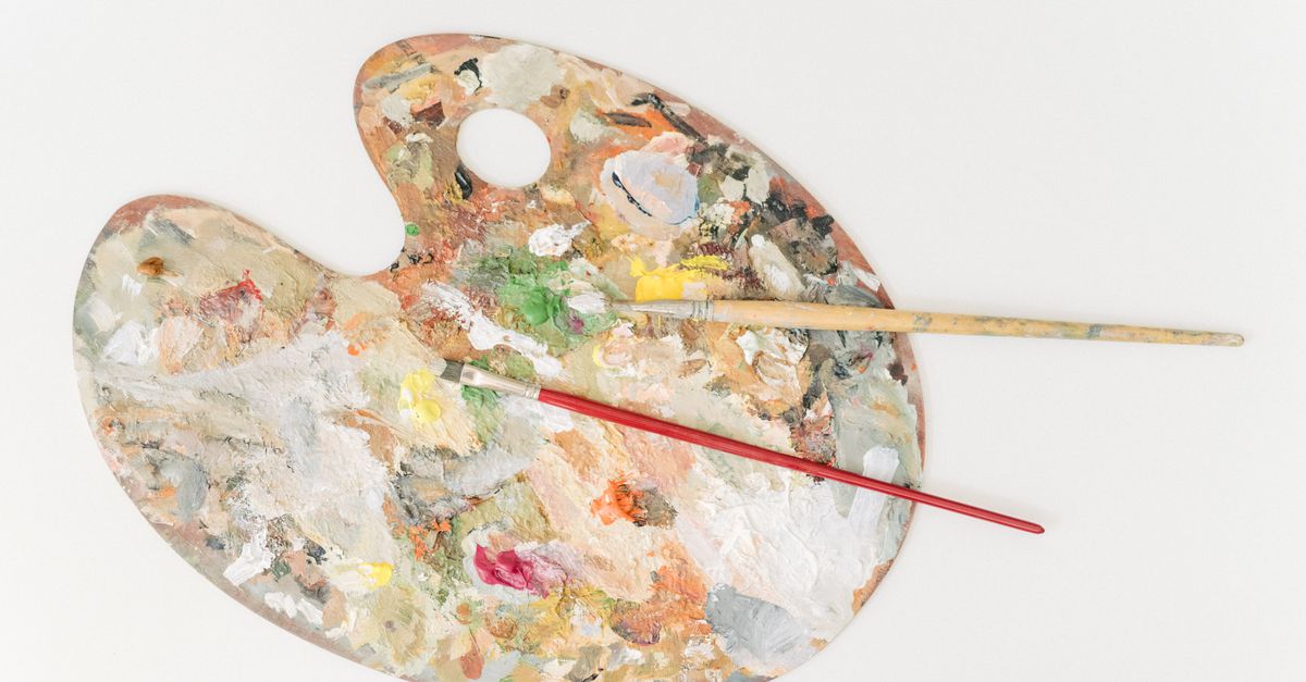 Vibrant artist's palette with colorful paint and brushes for creative projects.